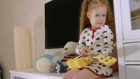 4K Video : Little child playing ukulele on sofa