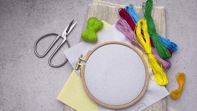 Embroidery hoop, fabric, thread and other accessories on the table. 