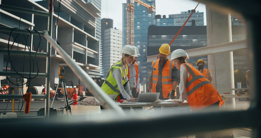 Establishing Footage of Female and Male Engineers and Architects Having a Conversation During a Meeting at a Building Site. Specialists Using Laptop Computer to Discuss Details on a Construction Plan Royalty-Free Stock Footage #3434904857