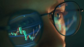 Trader wearing glasses is working on laptop computer. Screen with stock market charts and Bitcoin BTC or Ethereum ETH data analysis reflection. Broker trading online. Altcoins crypto currency trading - Powered by Shutterstock - Get 15% off with code: PIKWIZARD15