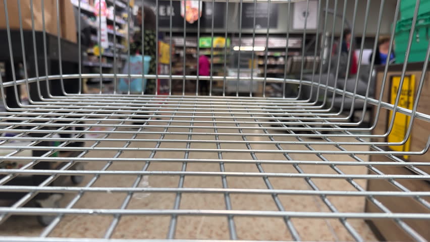 British supermarket view from empty shopping trolley or cart, stopping at bakery. Selective focus on foreground. Royalty-Free Stock Footage #3435012065