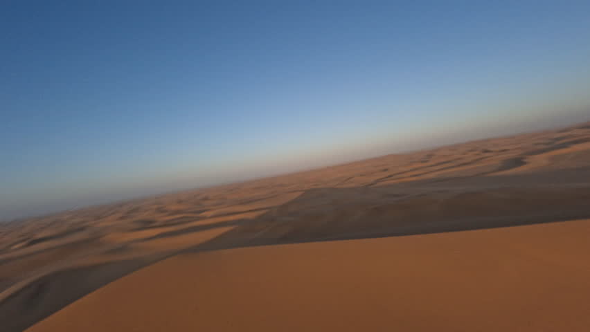 Aerial view with FPV drone flying fast over the beautiful dunes of Namibia near the coast on a beautiful sunset during an adventure trip to the African country