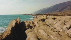 Smooth fly over the mud rough rocky beach in west coast Hormuz Island natural landscape of wonderful scenic sunset view skyline horizon water sport adventure trip camping near the beach pillar stone  - Powered by Shutterstock - Get 15% off with code: PIKWIZARD15