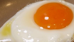 A close-up video of fried eggs made in a frying pan.
