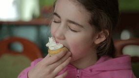 Child Eating Muffins Cupcakes Decorated With Sugar Cream. Girl Enjoying Vanilla Cupcakes with Frosting and Sprinkles. Unhealthy Junk Food. Hungry Sweet Tooth Child Bites Muffin with Sugar Frosting. - Powered by Shutterstock - Get 15% off with code: PIKWIZARD15