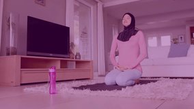 Animation of light spots over biracial woman in hijab practicing yoga. Lifestyle, domestic life and happiness concept digitally generated video.