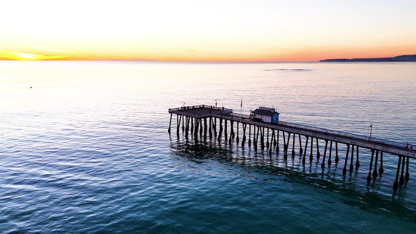 Aerial View of southern california pier with a beautful orange sunset
