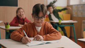 Angry playful noisy children classmates schoolgirl girl kid schoolboy child throw crumpled papers balls in little guy boy in glasses nerd writing task copybook bulling in primary school class lesson - Powered by Shutterstock - Get 15% off with code: PIKWIZARD15