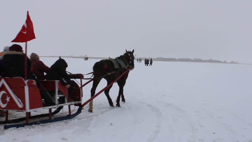 Sleigh pulled by a horse in lake frozen Cildir. Traditional Turkish winter fun.Kars winter tourism. Cildir Lake, Kars, Turkey
