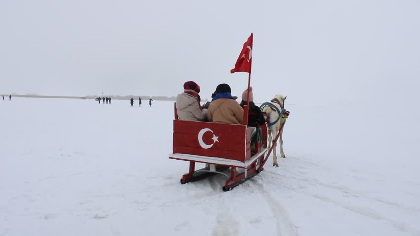Sleigh pulled by a horse in lake frozen Cildir. Traditional Turkish winter fun.Kars winter tourism. Cildir Lake, Kars, Turkey
