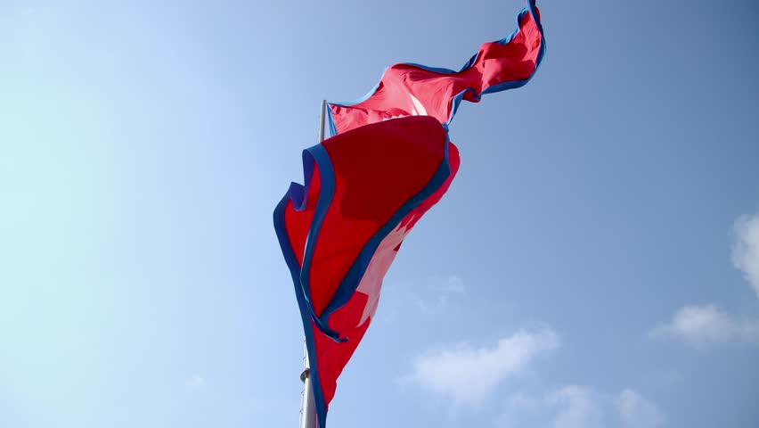 Nepal national flag. Nepal flag waving in the blue sky. Nepal Flag Flying High With Pride. 4k