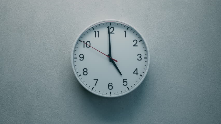 Cinematic Shot of White Office Wall Clock with Red Second Hand that counting down the Seconds to Twelve. Concept: Anticipation, Running out of Time, Deadline, Tension and Passage of time.