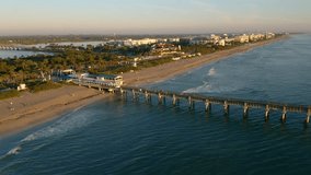 Drone 4K video heading northwest over the fishing pier at Lake Worth Florida at sunrise.
