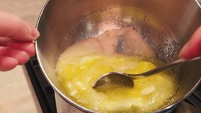 Melting butter honey sugar in a metal pan on steam of simmering water. POV cooking dessert. Baking cake. Preparing sweet dough for pie. Film grain pixel texture. Soft focus. Blur. Live camera - Powered by Shutterstock - Get 15% off with code: PIKWIZARD15