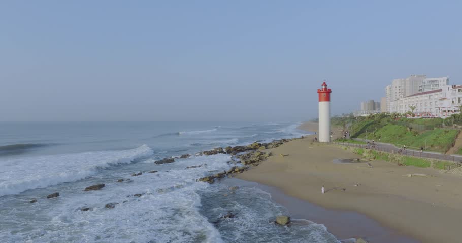 Umhlanga lighthouse and coastline with waves crashing on beach, durban, south africa, daytime, aerial view
