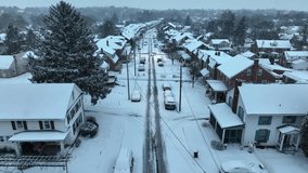 Snow flurries over snowy small town USA street during winter. Aerial flight above snow covered road in America during dawn. - Powered by Shutterstock - Get 15% off with code: PIKWIZARD15
