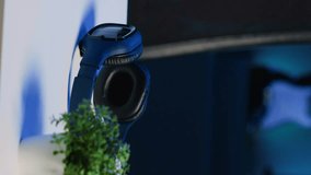 Vertical video Office desk filled with personal items in empty home interior illuminated with RGB lights at night. Laptop, headphones and mini house plants on table in apartment room, camera A close - Powered by Shutterstock - Get 15% off with code: PIKWIZARD15