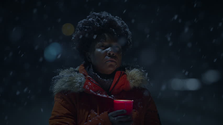 African Woman With Afro Hairstyle In Organge Clothes Outside in Strong Snowfall