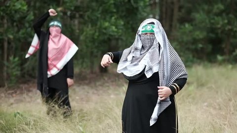 Two female teenager cover their faces with keffiyeh shouting angrily
