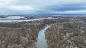 River winter floodplain delta Zastudanci meander drone aerial inland video shot in sandy sand alluvium freezing cold national nature reserve, benches forest and lowlands wetland swamp, view flying fly