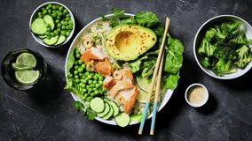 Salmon avocado bowl with broccoli, green peas, rice and fresh salad. Healthy food, poke bowl salad. Stock footage video 4k