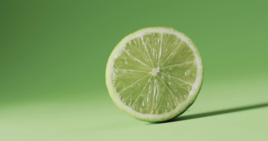 Composition of abstract shapes over halved lime on green background. Fruit, vegetarian food and organic healthy produce concept.