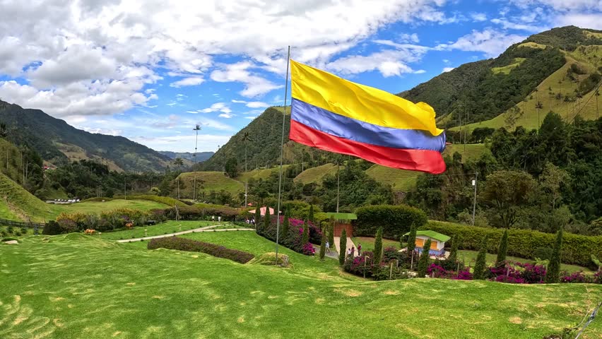 Colombian flag waving on the vally of cocora in salento, quindio, colombia, next to the palm trees and green grass Royalty-Free Stock Footage #3435775203