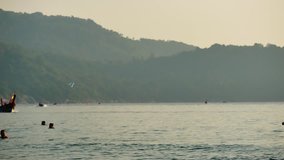 Life video The fishermen sailed through group of long-tail boats floating in the andaman sea with golden light of the Sun before sunset in life and transportation concept.