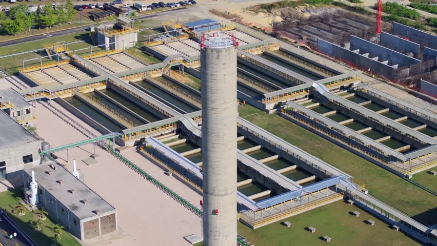Aerial telephoto orbit around basin at water treatment plant, salinity barrier