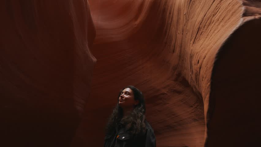 Young woman looking up at Antelope Canyon, Arizona, smooth wavy sandstone walls. Royalty-Free Stock Footage #3435822965