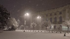 Winter in Bucharest. 4K video during a night snowfall on the streets of the city, view to the Royal Palace and the National Museum of Art. Travel to Romania.