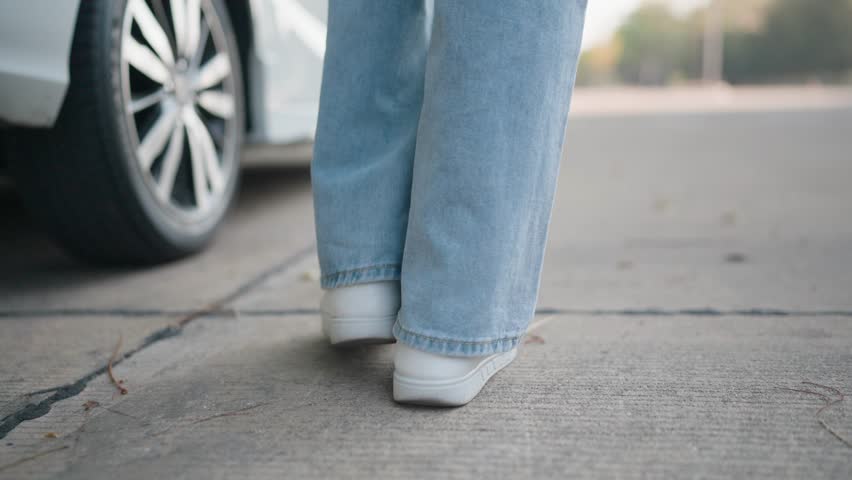 A cool woman walked towards an electric car. She opened the door and went inside. people and transportation Unlock and sit. Successful lifestyle, stylish look, motivation in life. Holiday for business
