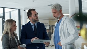 Pharmaceutical sales representatives meeting doctor in medical building. Hospital director and manager talking with head physician in modern clinic, hospital. - Powered by Shutterstock - Get 15% off with code: PIKWIZARD15