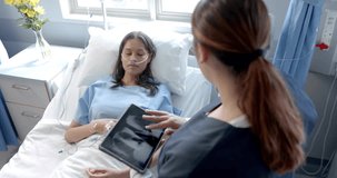 Animation of dna strand over diverse female doctor and patient in hospital. Global medicine, science, data processing and digital interface concept digitally generated video.
