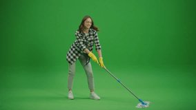 Green Screen.A Smiling Young Woman Housewife in Yellow Rubber Gloves is Washing the Floor with a Mop and Dancing. Virtual Consultations for Appliance Cleaning. Cleaning Hacks for Specific Appliances. - Powered by Shutterstock - Get 15% off with code: PIKWIZARD15