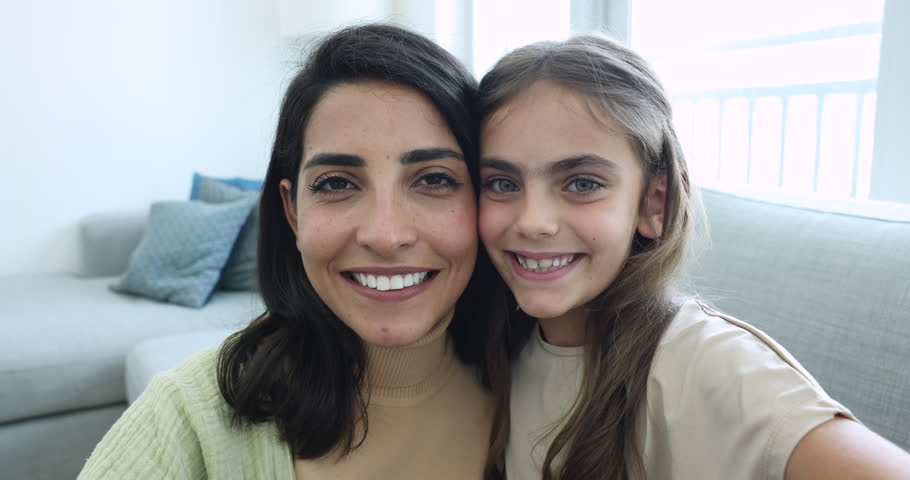Close up happy mom and adopted daughter take selfie portrait, show love sign, heart gesture, look at camera through joined fingers. Smiling foster mom with little kid girl have fun. Adoption, custody Royalty-Free Stock Footage #3436152933