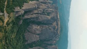 Vertical video. Meteora, Kalabaka, Greece. Meteora - rocks, up to 600 meters high. There are 6 active Greek Orthodox monasteries listed on the UNESCO list, Aerial View, Point of interest