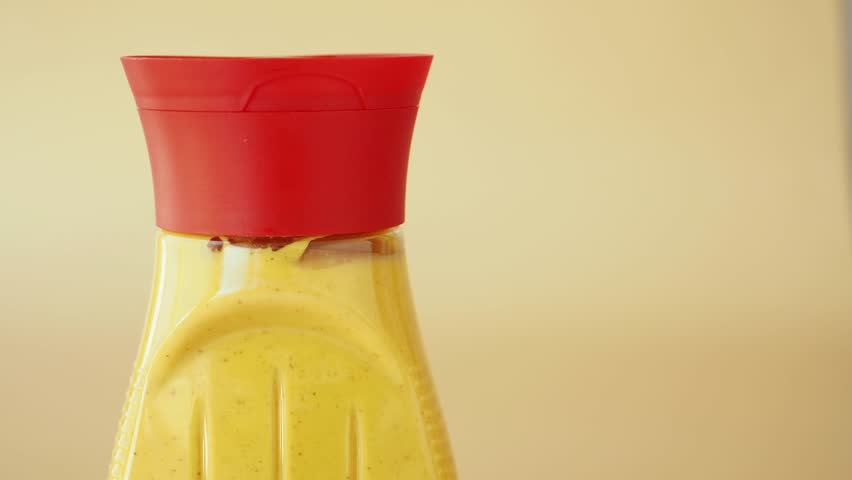 mustard mayonnaise in yellow container on yellow background 