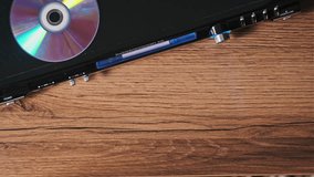 Compact disc is ejected from the DVD player. Male hand unloads CD from a CD player tray close-up. Music, movies, or data recorded on a laser optical information storage medium. Unloading Compact Disc