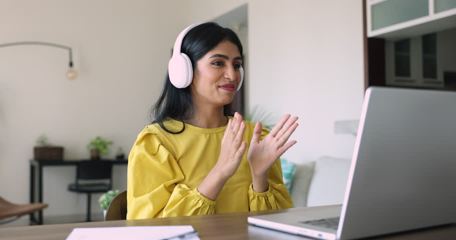 Indian woman wear headphones lead conversation seated at desk staring at laptop screen provide information to client, give professional psychological consultation. On-line counseling, videocall event Royalty-Free Stock Footage #3436225779
