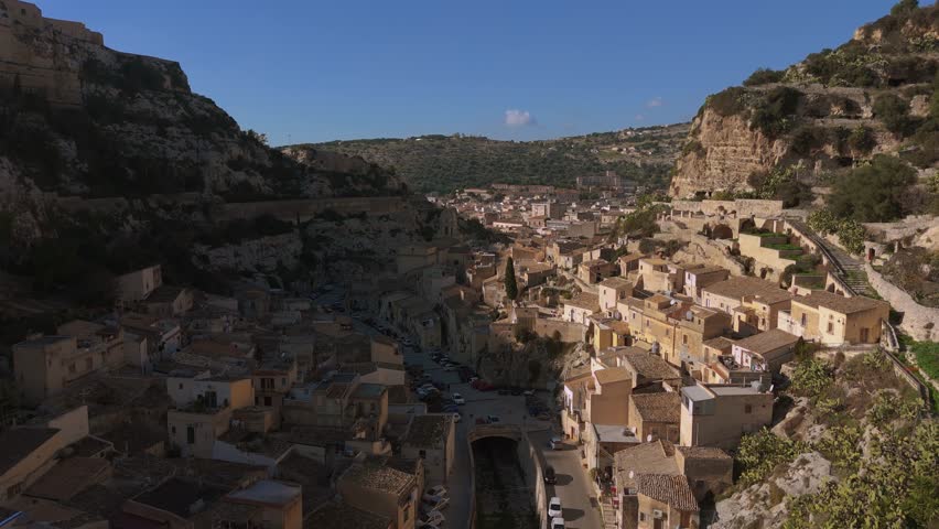Scicli, scenic mountain village with old housesl in Sicily. Scenic canyon aerial.