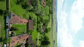 Vertical video of Viscri Village. Drone tracking right above the village. Beautiful traditional houses. Famous travel destination in Brasov, Romania. Countryside of Romania. Green, natural landscape.