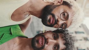 Vertical video, Homosexual couple stands hugging and takes selfie on street of old city