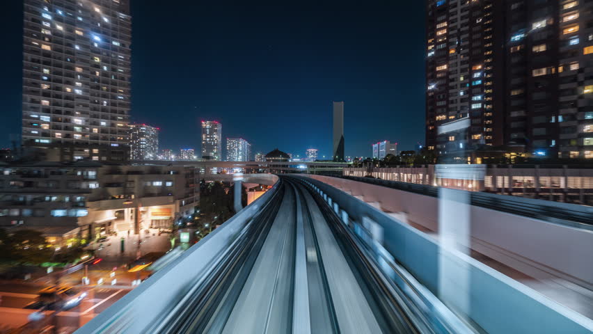 Motion timelapse POV shot from automated train at night in Tokyo, Japan. Royalty-Free Stock Footage #3436436611