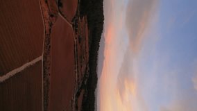 Beautiful orange sunrise above the agriculture fields in Catalonia, province of Barcelona. Vines field. In Background famous Montserrat Mountains. Drone panning left. Underexposed video. Vertical  - Powered by Shutterstock - Get 15% off with code: PIKWIZARD15