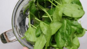 Cooking spinach smoothie in blender. Pouring green vegetable leaves in blender. Slow motion. Healthy drink concept. Top view - Powered by Shutterstock - Get 15% off with code: PIKWIZARD15