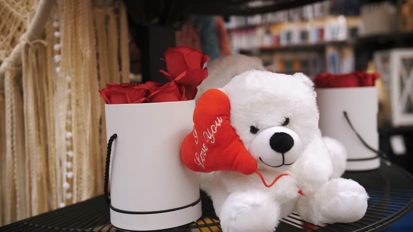 Happy Valentine's Day. close-up. a white toy bear with a red ribbon and a heart, next to it is a box of red roses, as a romantic gift for Valentine's Day. Royalty-Free Stock Footage #3436559205