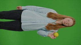 Split Green Screen. Vertical Video Teenage Girl Smiles As She Eats An Apple, Embodying. Healthy Eating And School Nutrition. A Vivid Depiction Of Youth Embracing Nutritious Choices In Their Daily Diet