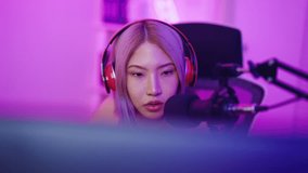 Asian beautiful esport woman gamer play online video game on computer. Attractive young girl gaming player feel happy and enjoy technology broadcast live streaming while plays cyber tournament at home