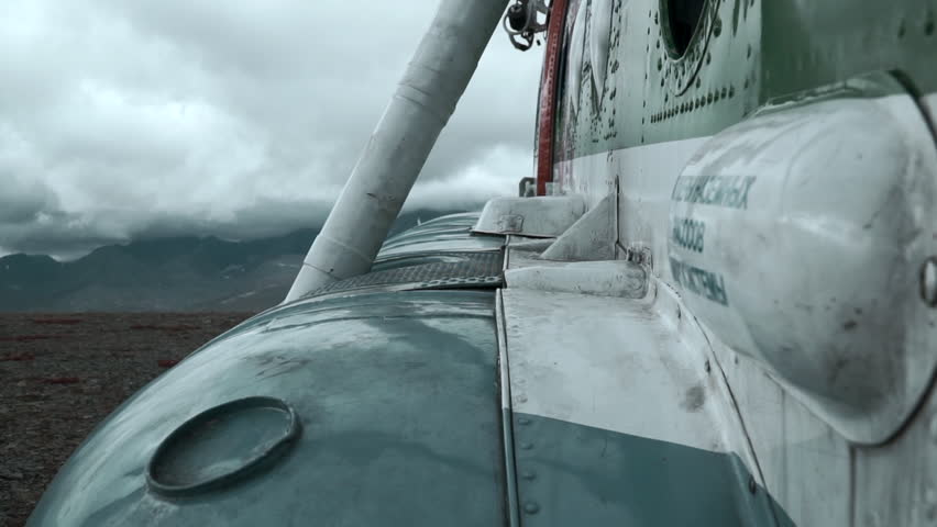 Close up of old rusty airplane on a hill top. Clip. Aircraft exterior details with heavy clouds and mountains on the background. Royalty-Free Stock Footage #3436713521